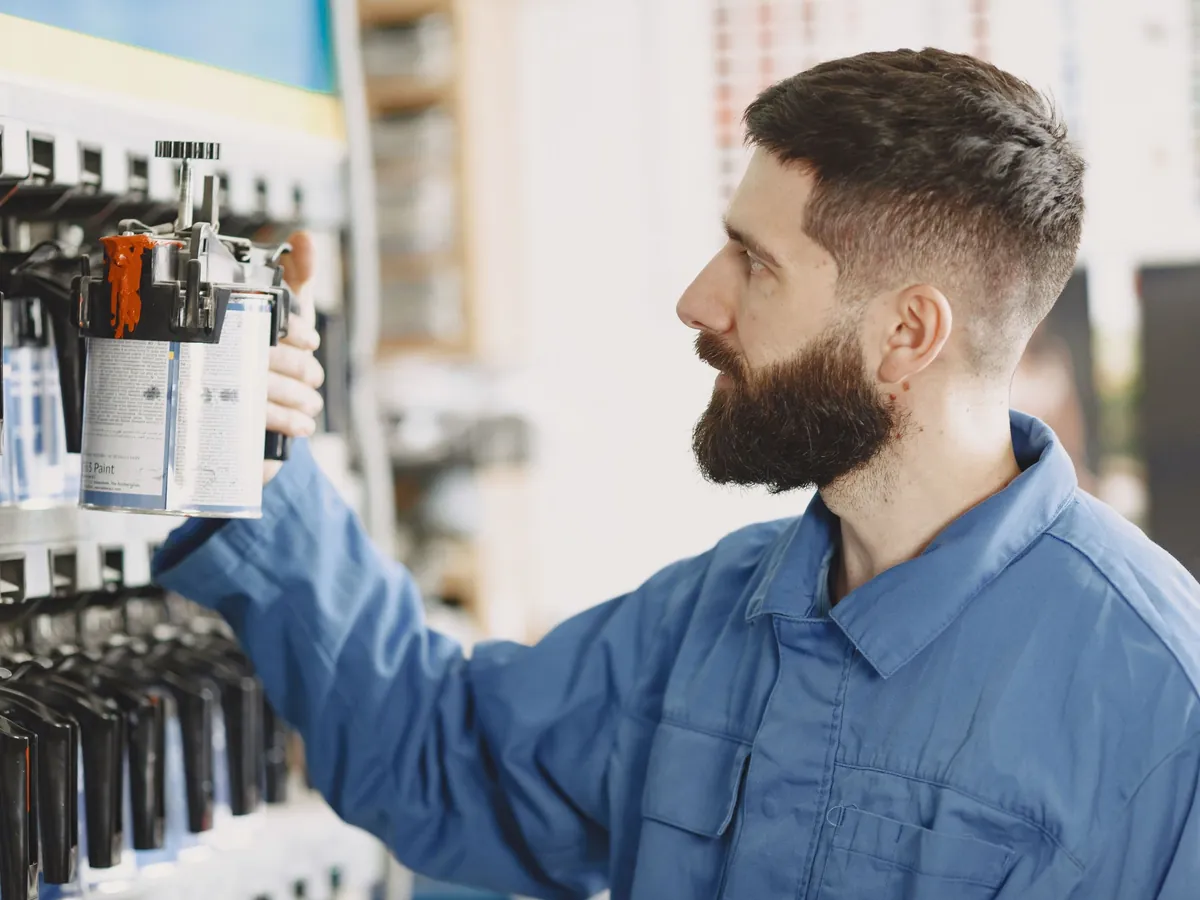 Meccanico che sceglie olio e filtri dallo scaffale dell'officina
